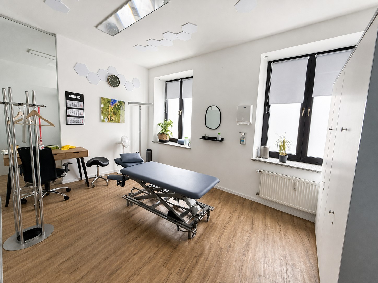 Behandlungsraum mit Therapieliege und zwei Fenstern